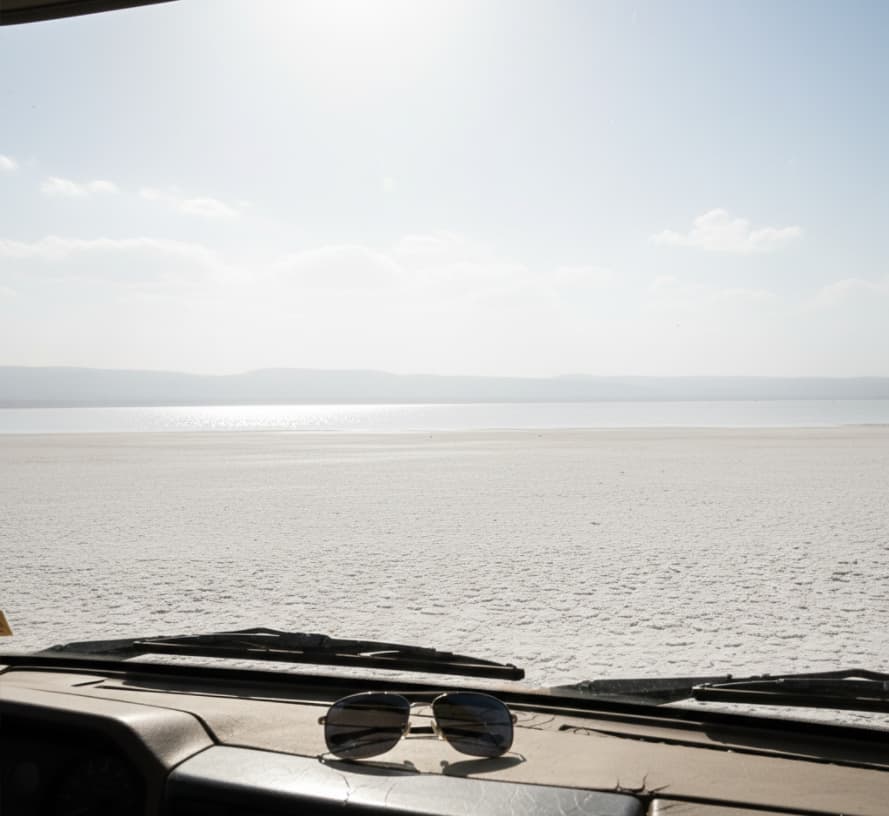 The Ultimate Lake Nakuru Safari Packing List (2026 Logistical Guide) 4 Intense sunlight reflecting off the white alkaline shores of Lake Nakuru, demonstrating the need for polarized lenses.