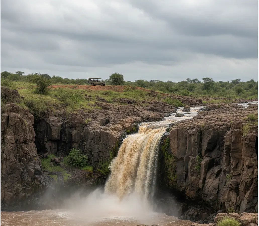 Wide view of Makalia Falls Lake Nakuru with a safari 4x4 parked in the distance.
