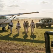 A private charter aircraft landing at a Masai Mara airstrip during a luxury safari group arrival.