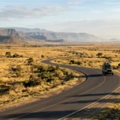 A safari vehicle driving on the tarmacked Ngong-Suswa bypass road in the Great Rift Valley.