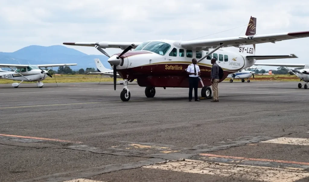 Nairobi to Masai Mara Flights 2026: Wilson Airport Guide 2 Travelers boarding a domestic safari flight at Wilson Airport Nairobi for Masai Mara