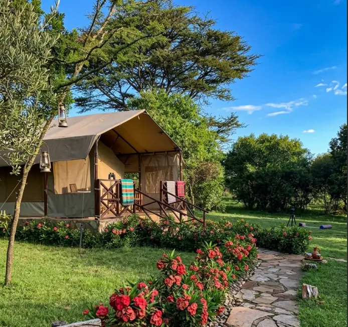 Best Budget Masai Mara Camps 2026: The Gate Proximity Guide 5 Raised safari tent with a wooden balcony and stone path at budget camps in masai mara