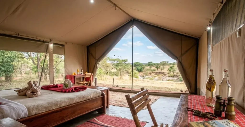Interior view of an en-suite canvas tent at Hammerkop Migration Camp with a wide open front looking out onto the Masai Mara savanna.