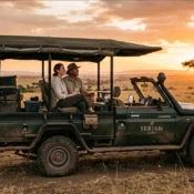 An open-sided luxury safari vehicle parked on the golden plains during a Masai Mara honeymoon safari